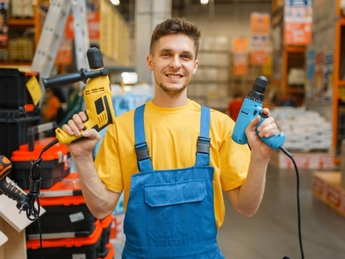 Man holding two drilling machines, showcasing power tools available at Starlinks